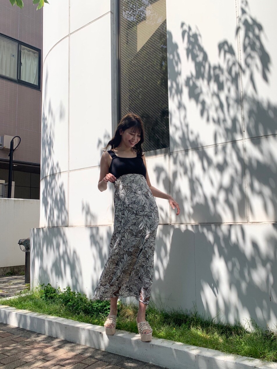 ブラック系のワンピース、ホワイト系のサンダルを着用したレディースの春コーディネートの3枚目の写真