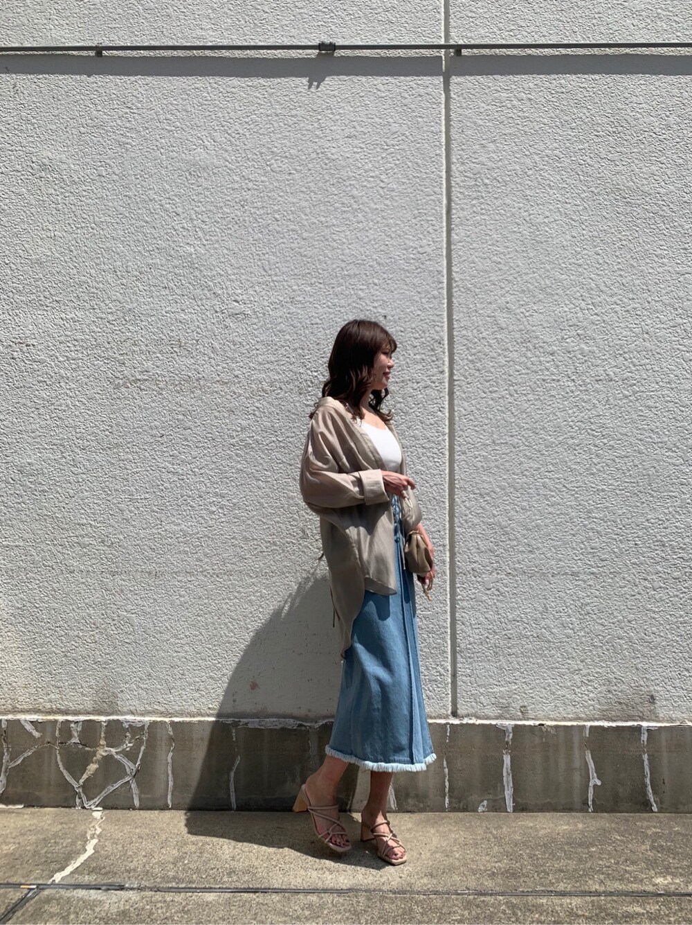 ベージュ系のシャツ/ブラウス、ブルー系のスカートを着用したレディースの夏コーディネートの2枚目の写真