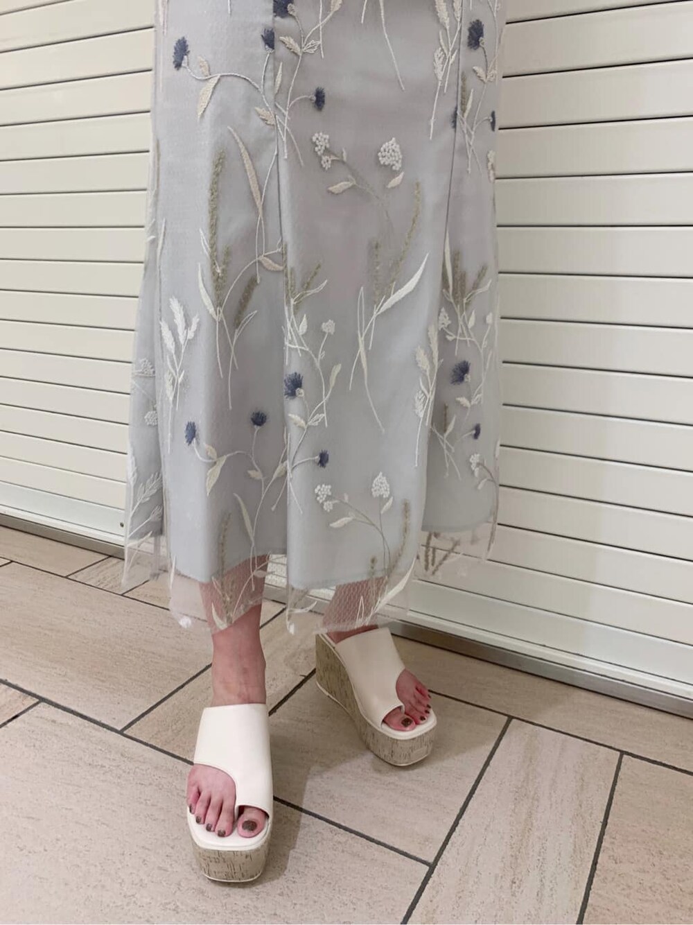 グリーン系のワンピース、ホワイト系のサンダルを着用したレディースの夏コーディネートの3枚目の写真