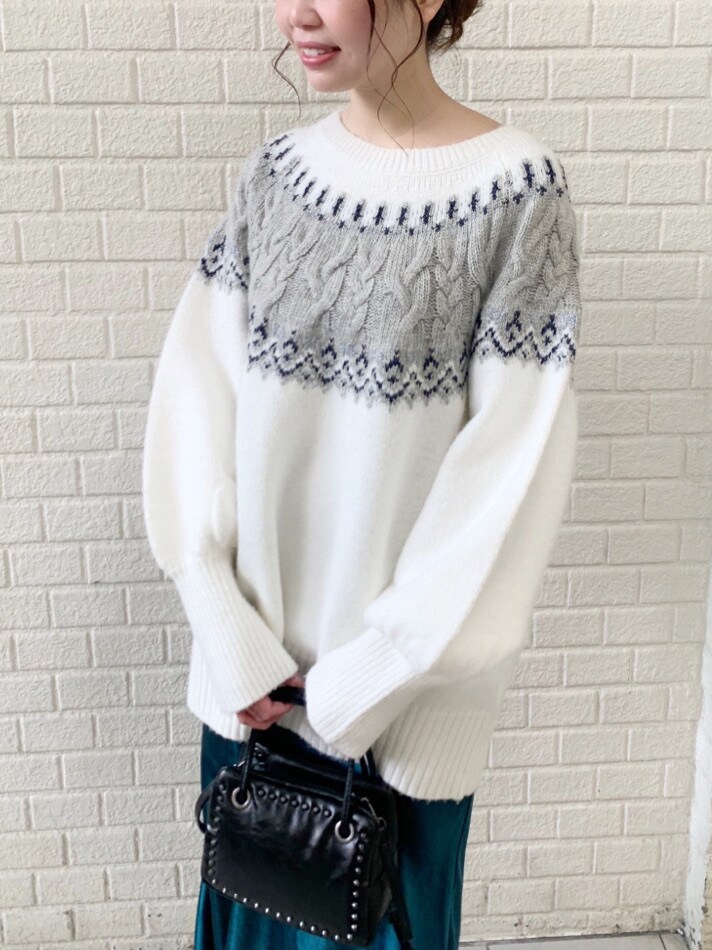 グリーン系のスカート、ホワイト系のニット/セーターを着用したレディースの冬コーディネートの3枚目の写真