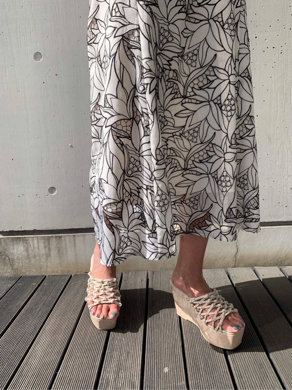 ブラック系のスカート、ホワイト系のサンダル、パープル系のニット/セーターを着用したレディースの春コーディネートの4枚目の写真