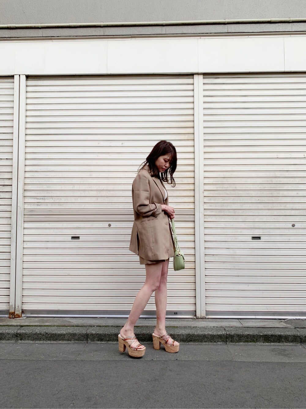 ブラウン系のその他パンツ、グリーン系のサンダル、ホワイト系のニット/セーターを着用したレディースの春コーディネートの2枚目の写真