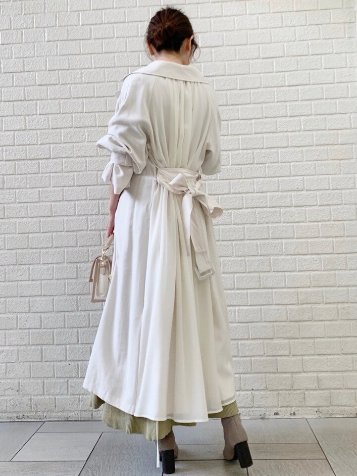 ホワイト系のトレンチコート、グリーン系のワンピースを着用したレディースの冬コーディネートの6枚目の写真