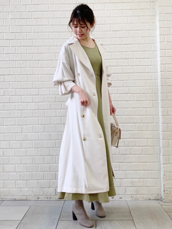 ホワイト系のトレンチコート、グリーン系のワンピースを着用したレディースの冬コーディネートの3枚目の写真