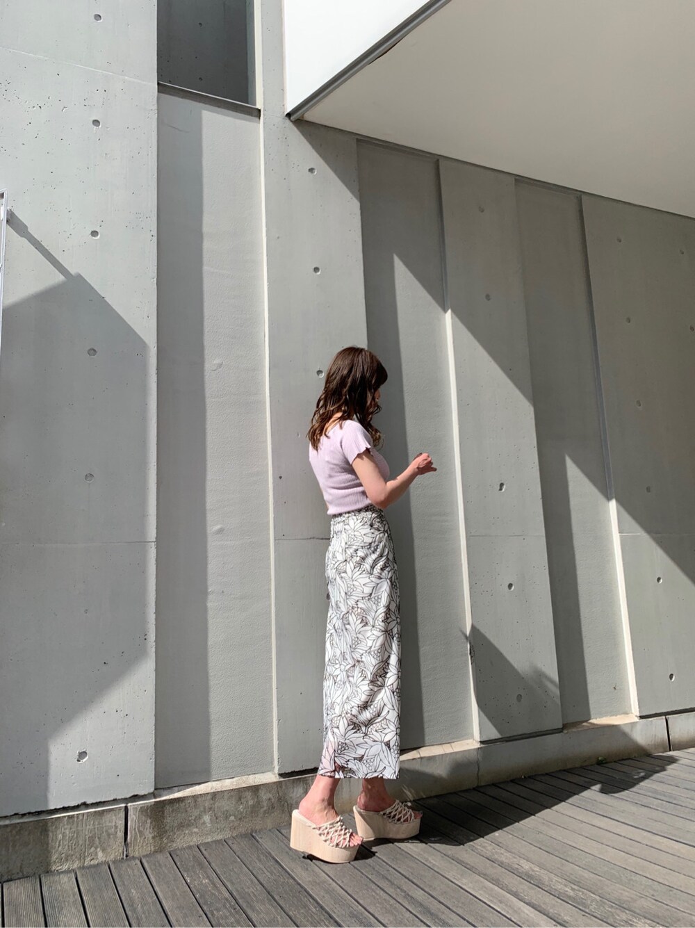 ブラック系のスカート、ホワイト系のサンダル、パープル系のニット/セーターを着用したレディースの春コーディネートの5枚目の写真