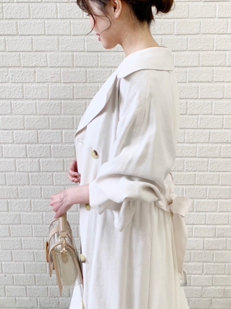 ホワイト系のトレンチコート、グリーン系のワンピースを着用したレディースの冬コーディネートの9枚目の写真