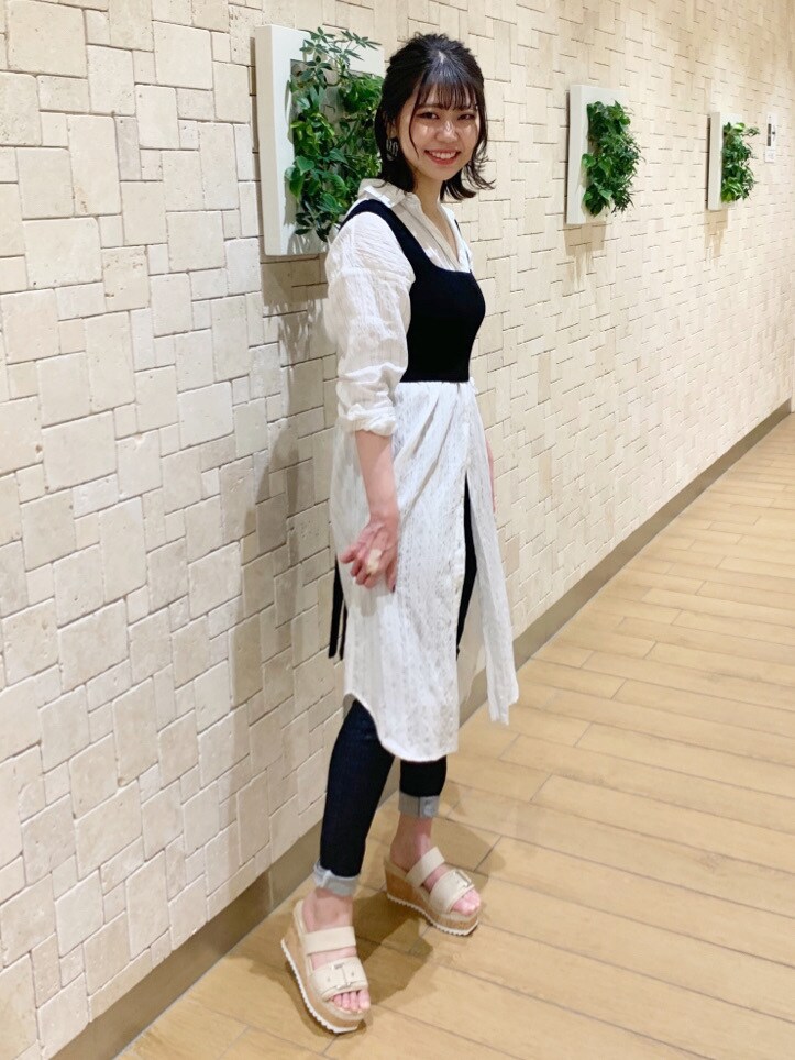 ブルー系のデニムパンツ、ホワイト系のワンピースを着用したレディースの冬コーディネートの2枚目の写真