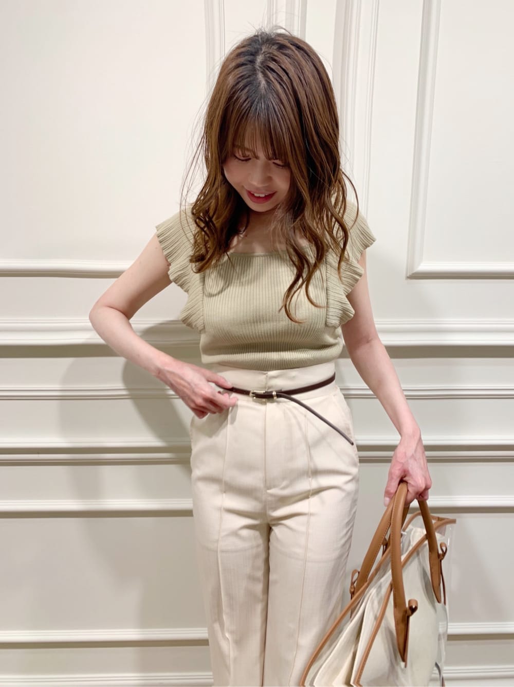 ブラウン系のトートバッグ、ホワイト系のその他パンツ、ホワイト系のサンダルを着用したレディースの春コーディネートの2枚目の写真