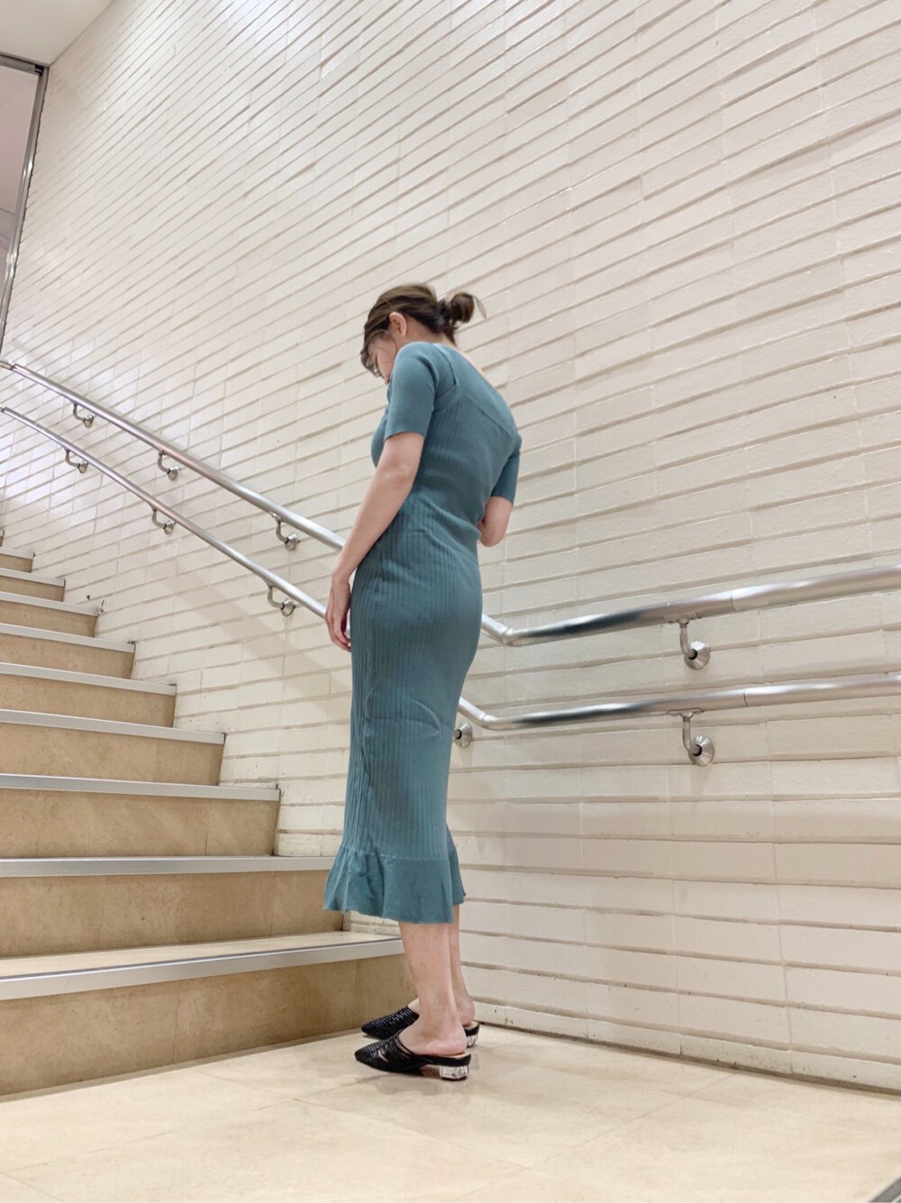 グリーン系のワンピース、ブラック系のサンダルを着用したレディースの春コーディネートの2枚目の写真