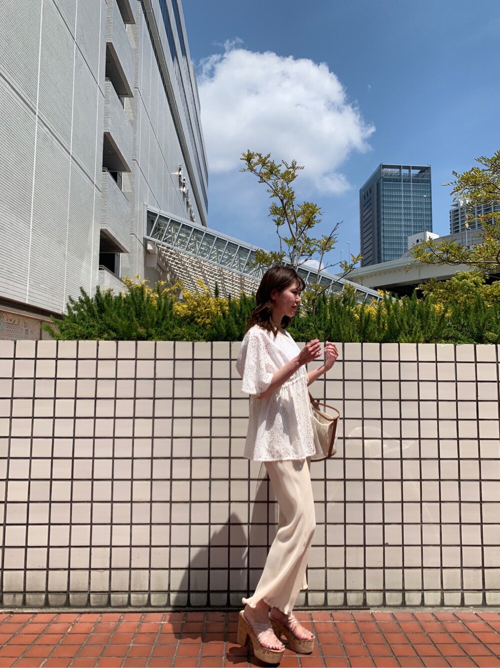 ブラウン系のトートバッグ、ホワイト系のシャツ/ブラウス、ホワイト系のその他パンツを着用したレディースの春コーディネートの3枚目の写真