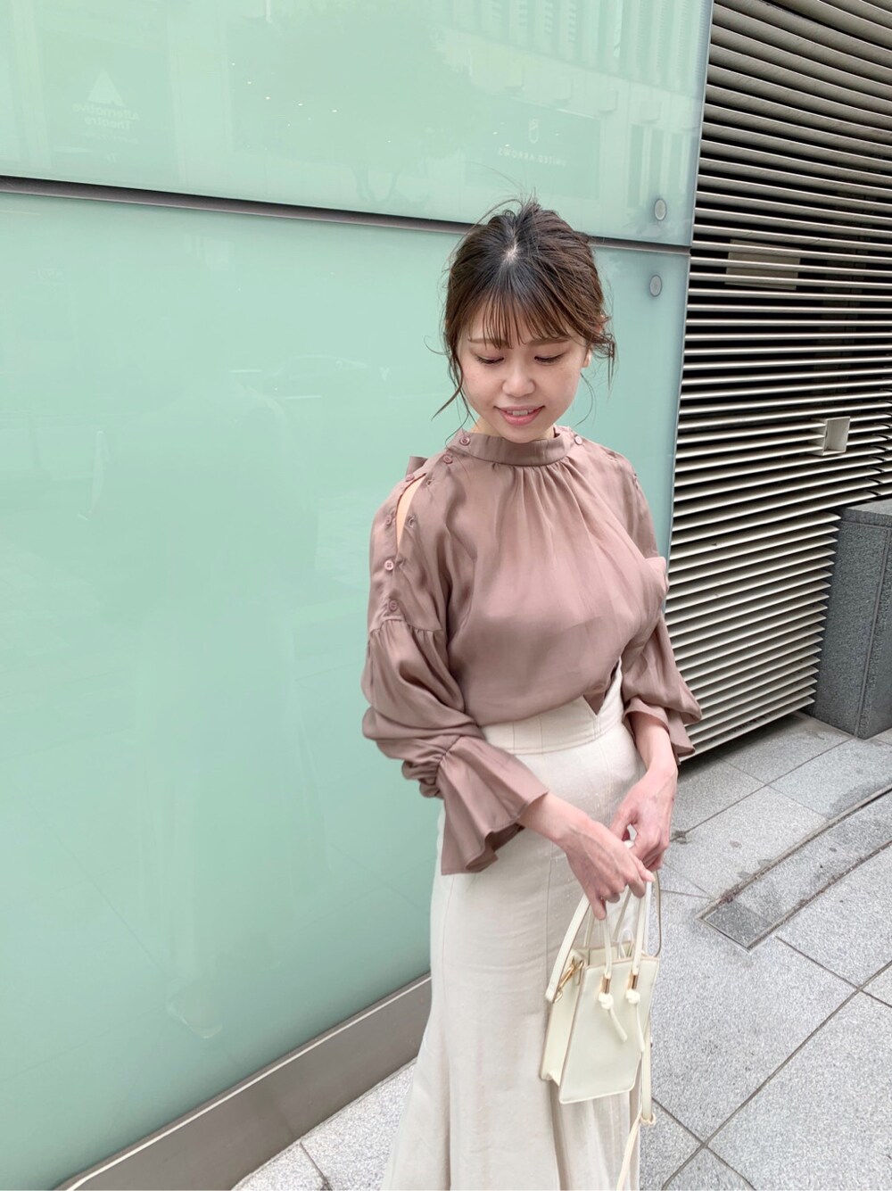 ホワイト系のスカート、シルバー系のサンダル、ホワイト系のハンドバッグを着用したレディースの冬コーディネートの5枚目の写真