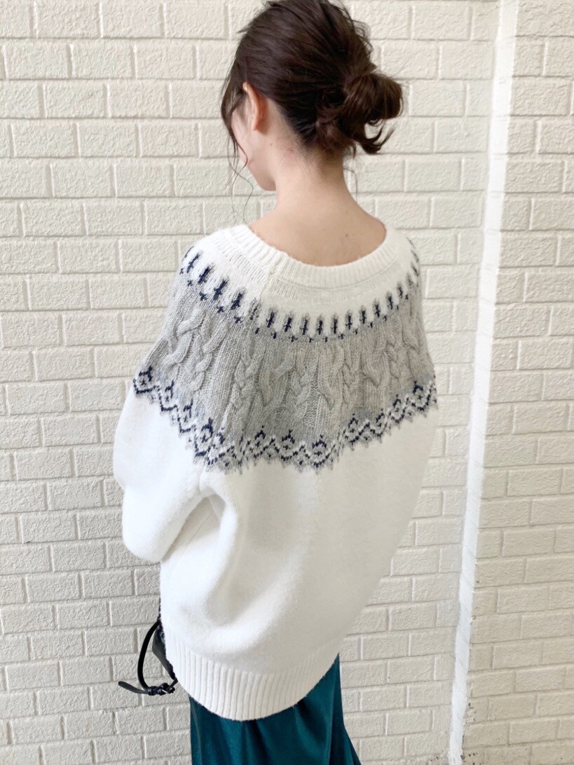 グリーン系のスカート、ホワイト系のニット/セーターを着用したレディースの冬コーディネートの4枚目の写真