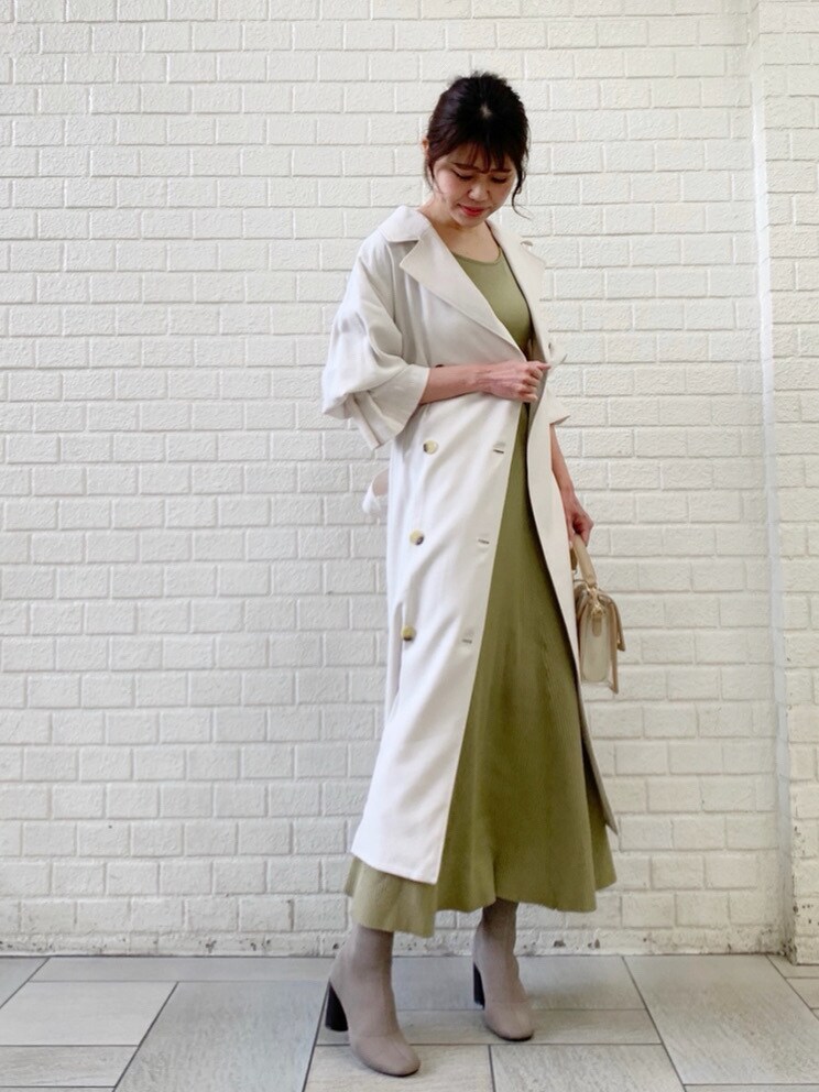 ホワイト系のトレンチコート、グリーン系のワンピースを着用したレディースの冬コーディネートの7枚目の写真
