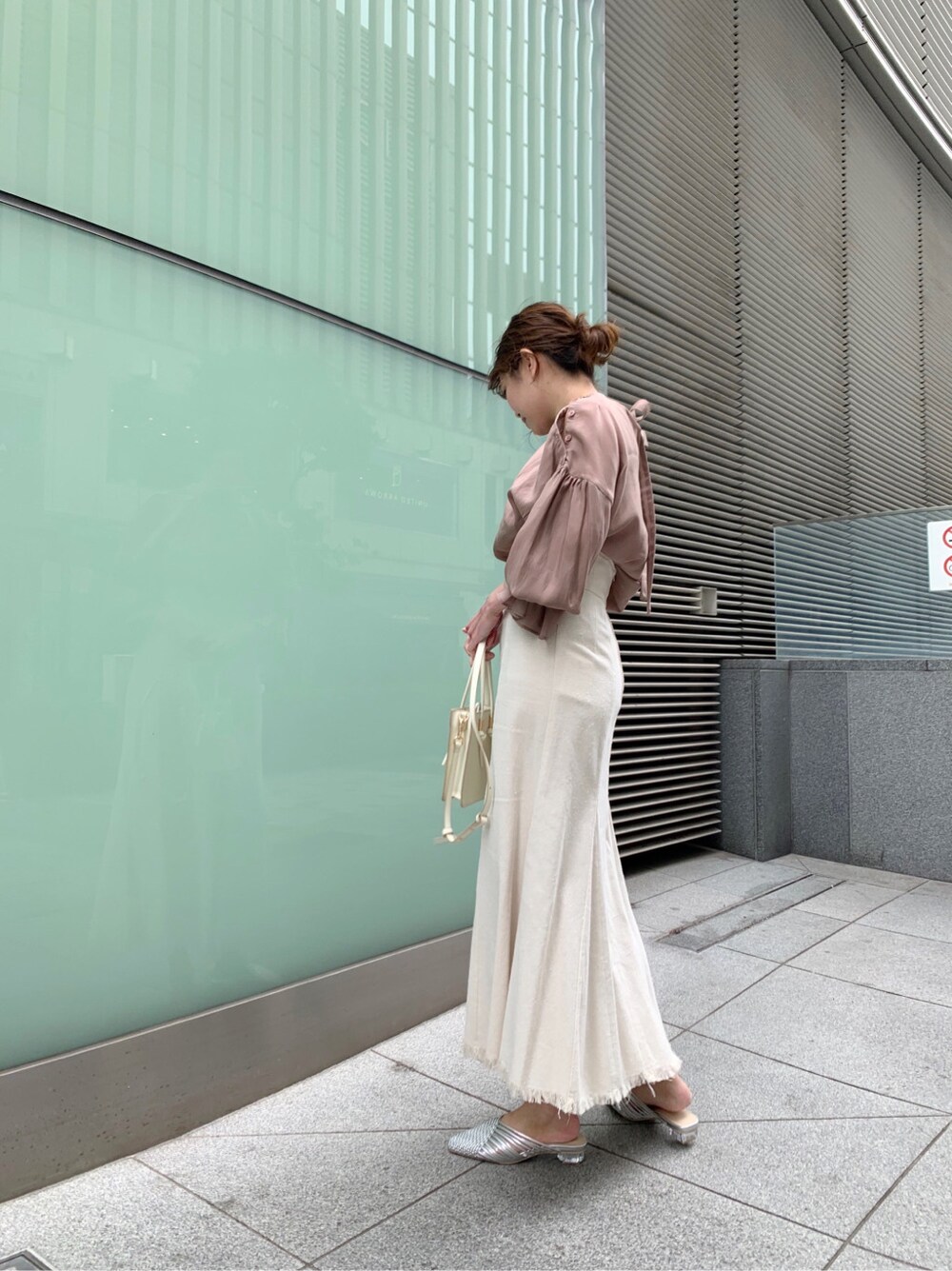 ホワイト系のスカート、シルバー系のサンダル、ホワイト系のハンドバッグを着用したレディースの冬コーディネートの4枚目の写真