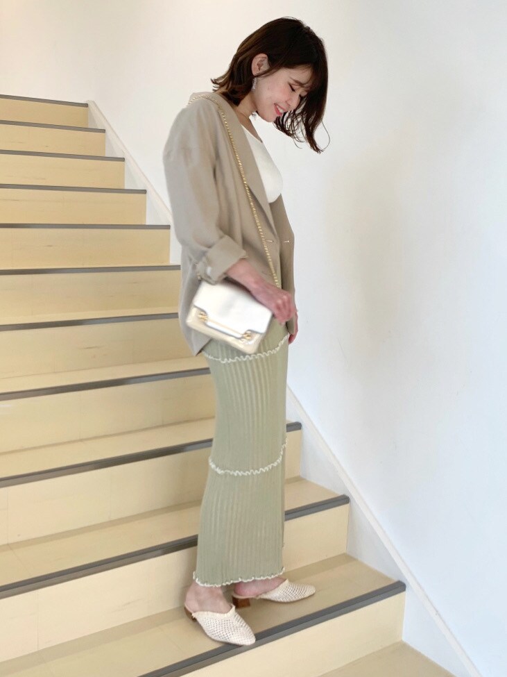 ベージュ系のパンプス、イエロー系のスカート、ホワイト系のニット/セーターを着用したレディースの春コーディネートの3枚目の写真