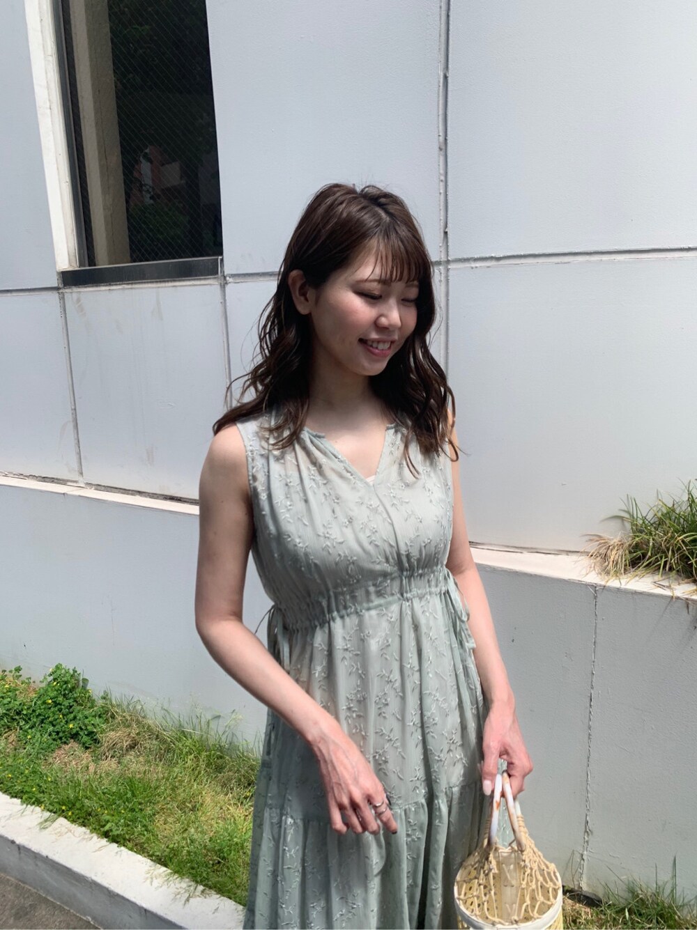 ホワイト系のハンドバッグ、グリーン系のワンピース、ベージュ系のサンダルを着用したレディースの夏コーディネートの3枚目の写真