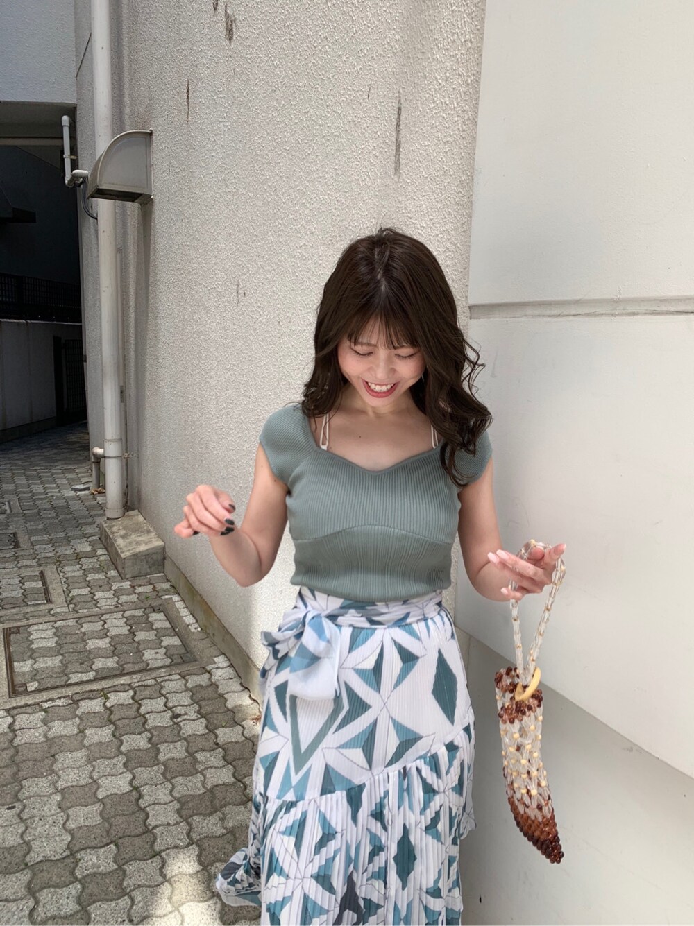 グリーン系のサンダル、ブルー系のスカート、グリーン系のニット/セーターを着用したレディースの春コーディネートの3枚目の写真