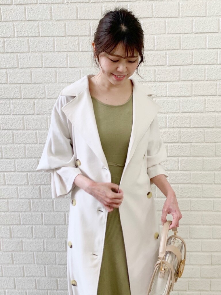 ホワイト系のトレンチコート、グリーン系のワンピースを着用したレディースの冬コーディネートの6枚目の写真