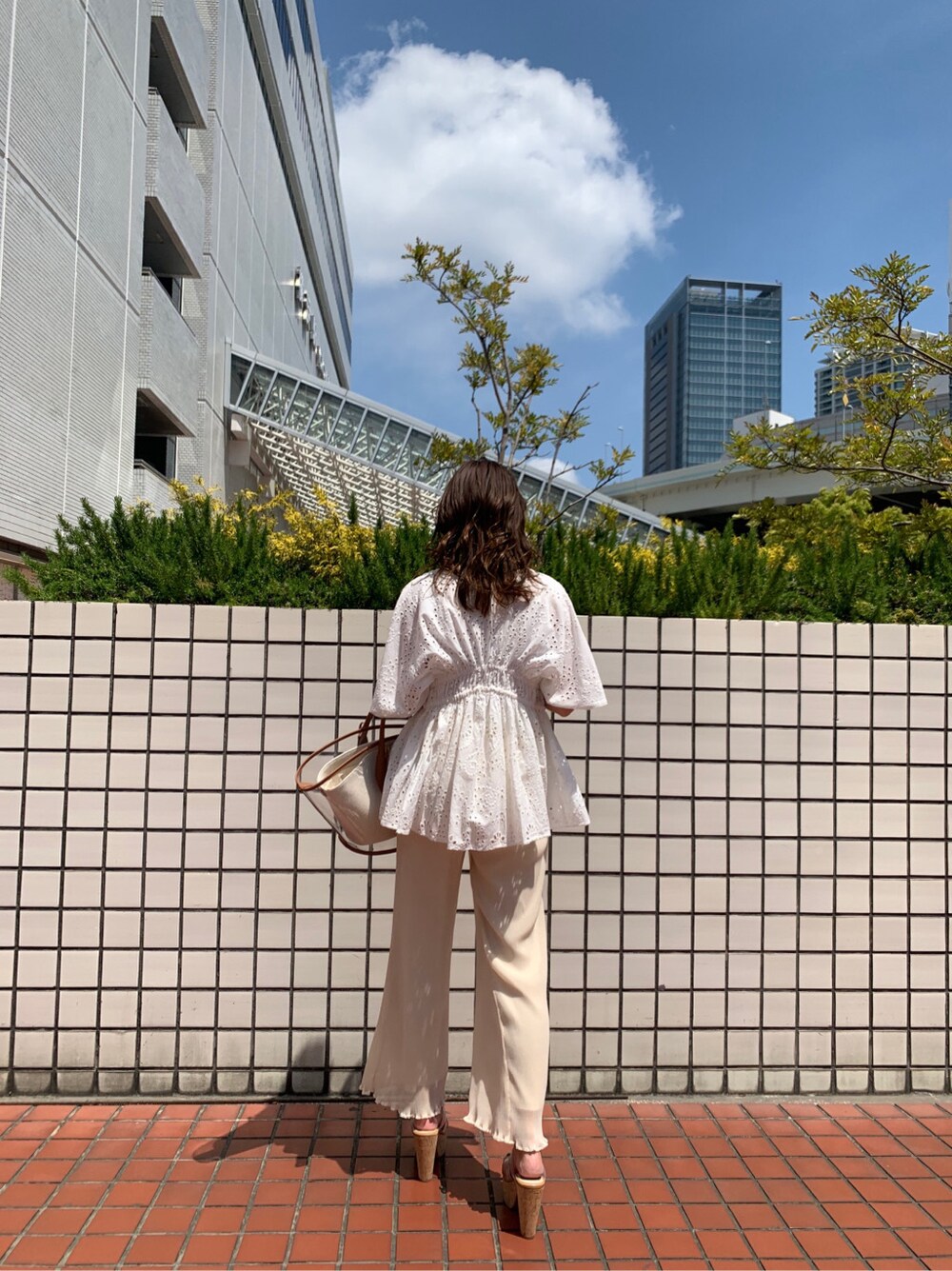 ブラウン系のトートバッグ、ホワイト系のシャツ/ブラウス、ホワイト系のその他パンツを着用したレディースの春コーディネートの4枚目の写真