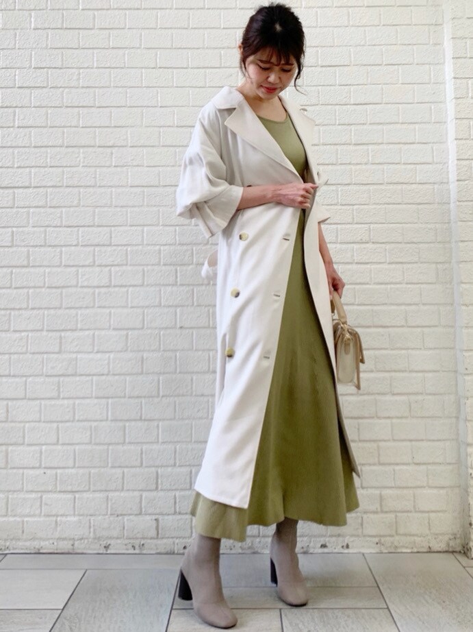 ホワイト系のトレンチコート、グリーン系のワンピースを着用したレディースの冬コーディネートの4枚目の写真