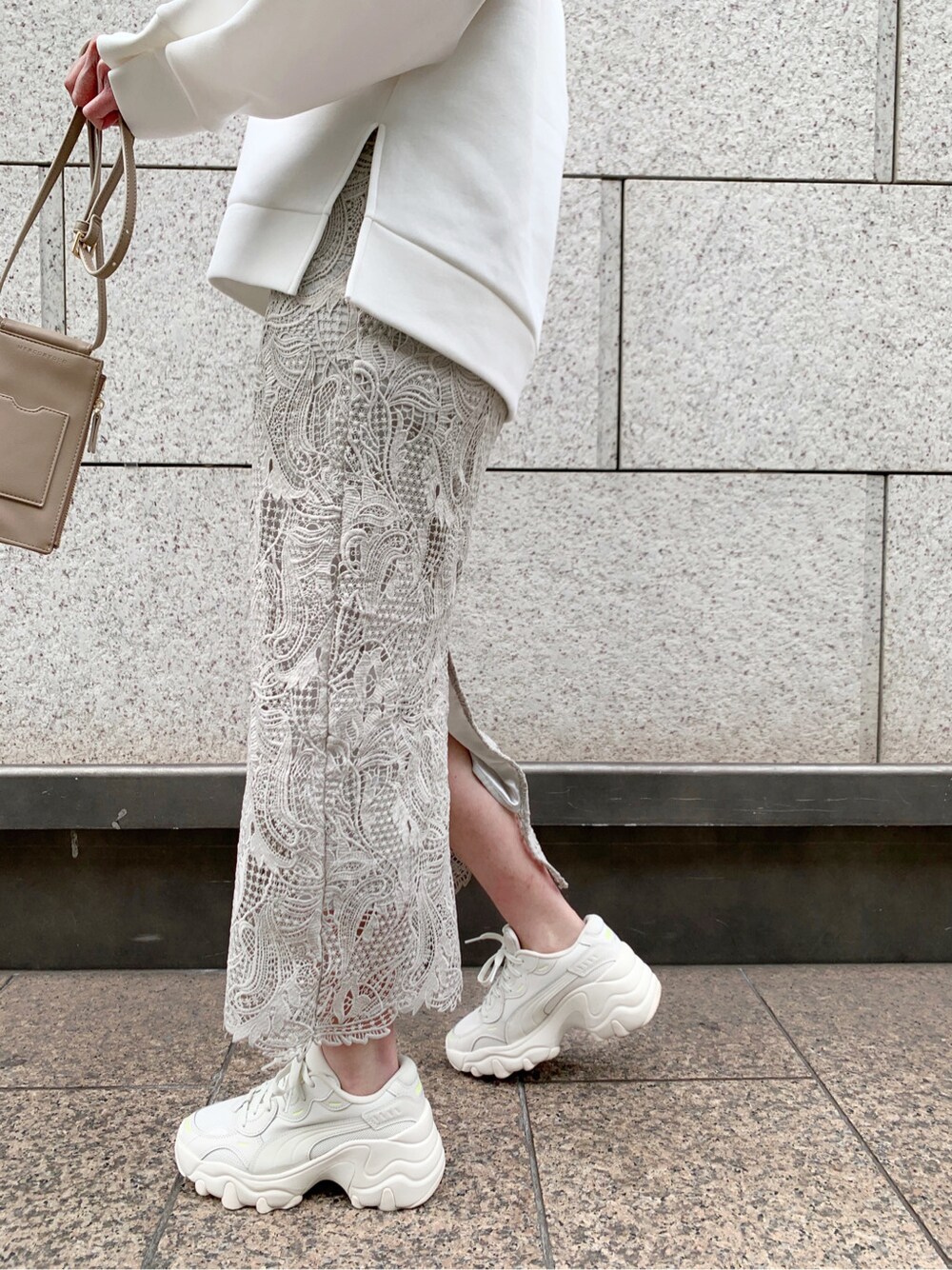 ベージュ系のショルダーバッグ、ホワイト系のTシャツ/カットソーを着用したレディースの冬コーディネートの4枚目の写真