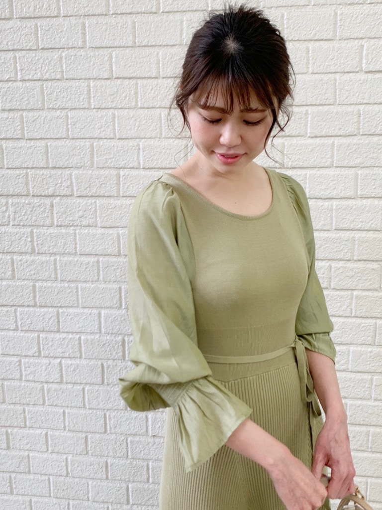 ホワイト系のトレンチコート、グリーン系のワンピースを着用したレディースの冬コーディネートの4枚目の写真