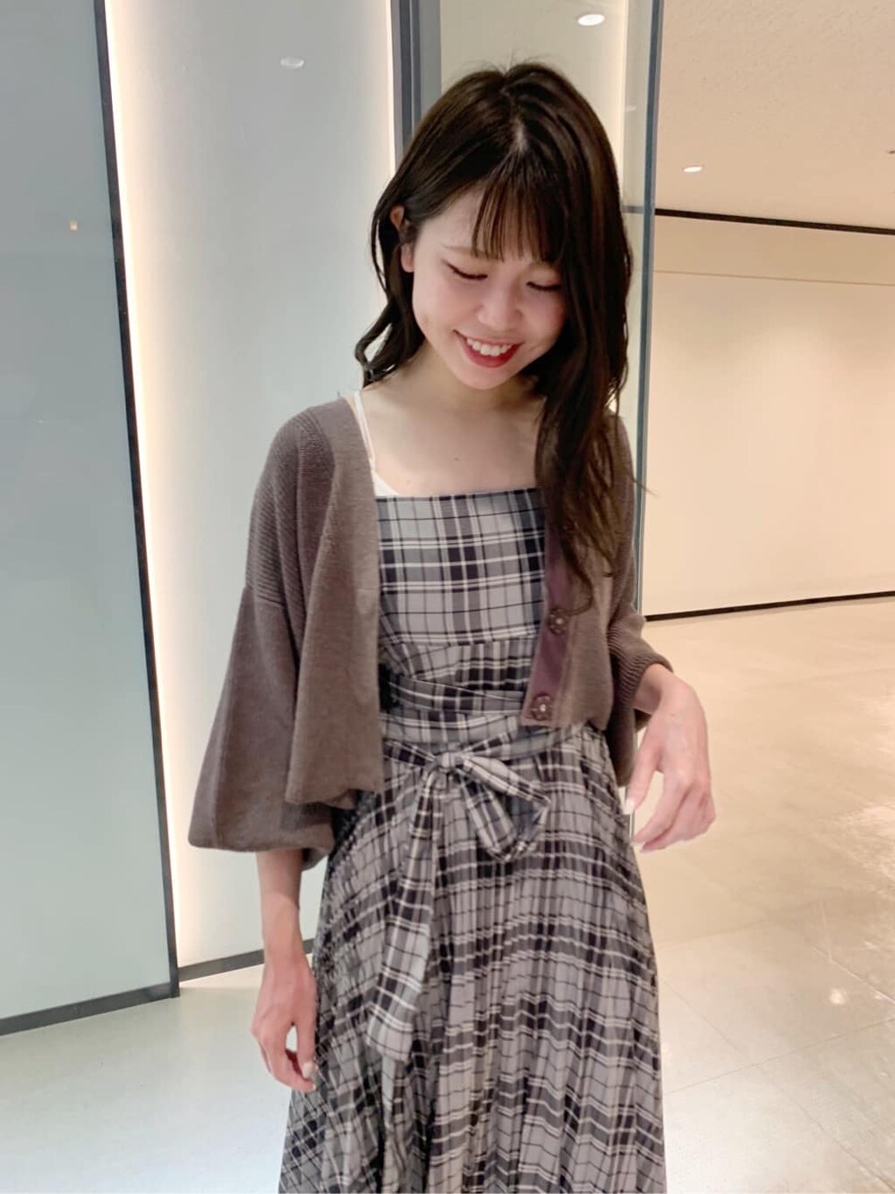 ブラック系のワンピース、ブラック系のその他シューズ、ブラウン系のカーディガン/ボレロを着用したレディースの夏コーディネートの4枚目の写真