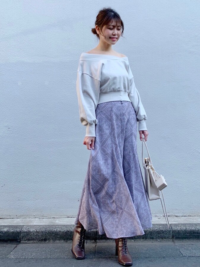 パープル系のスカート、ベージュ系のトートバッグ、ベージュ系のTシャツ/カットソーを着用したレディースの冬コーディネートの2枚目の写真