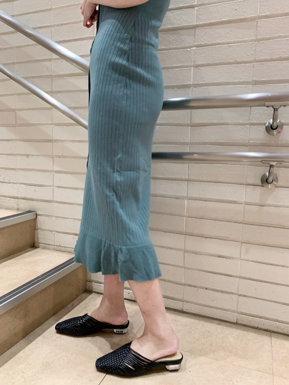 グリーン系のワンピース、ブラック系のサンダルを着用したレディースの春コーディネートの5枚目の写真