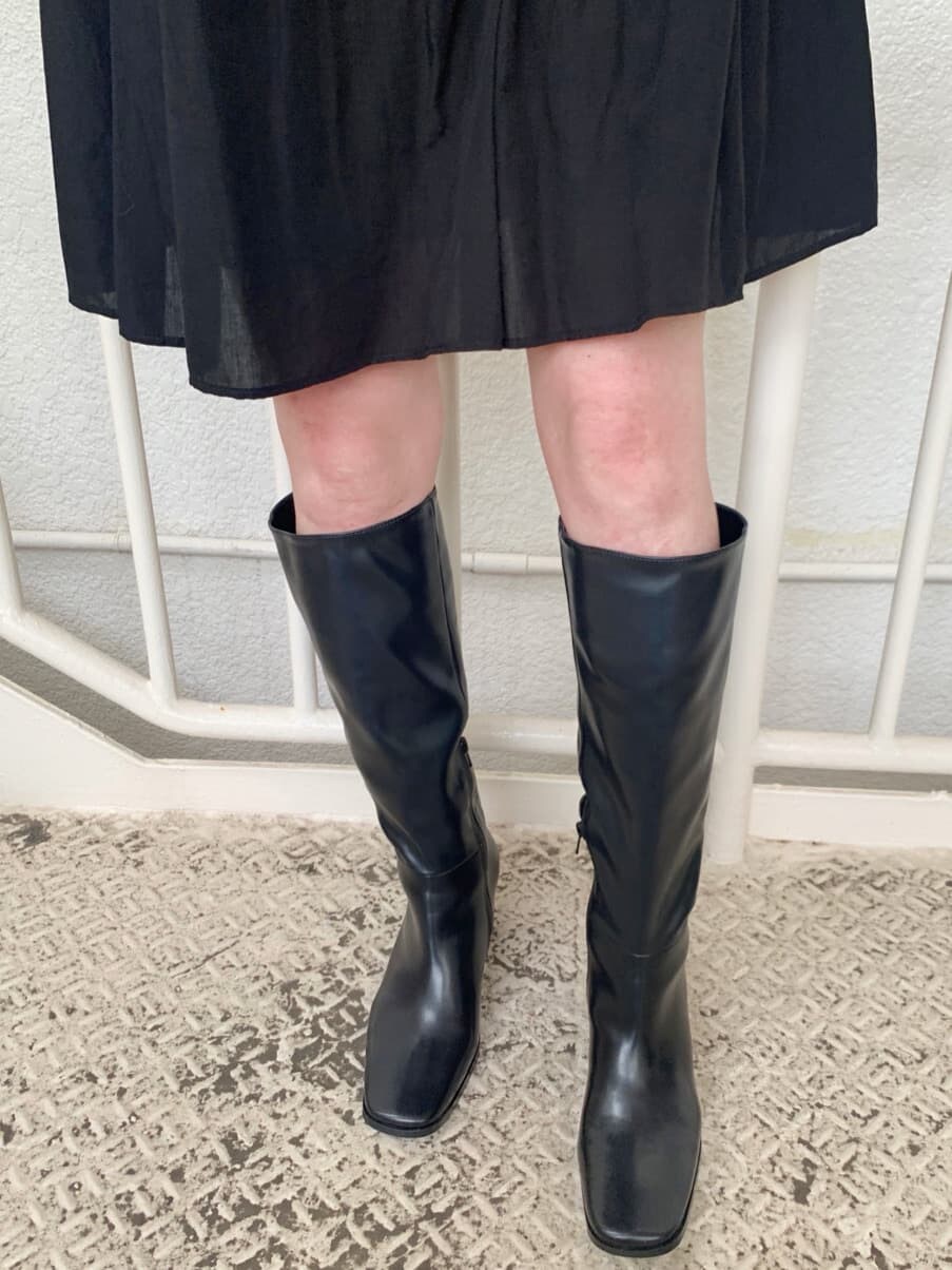 ブラック系のワンピース、ブラック系のブーツ、ブラック系のハットを着用したレディースの秋コーディネートの5枚目の写真