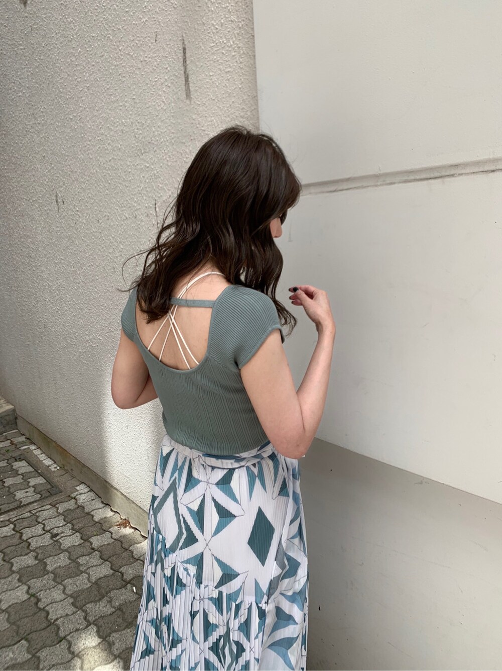 グリーン系のサンダル、ブルー系のスカート、グリーン系のニット/セーターを着用したレディースの春コーディネートの4枚目の写真