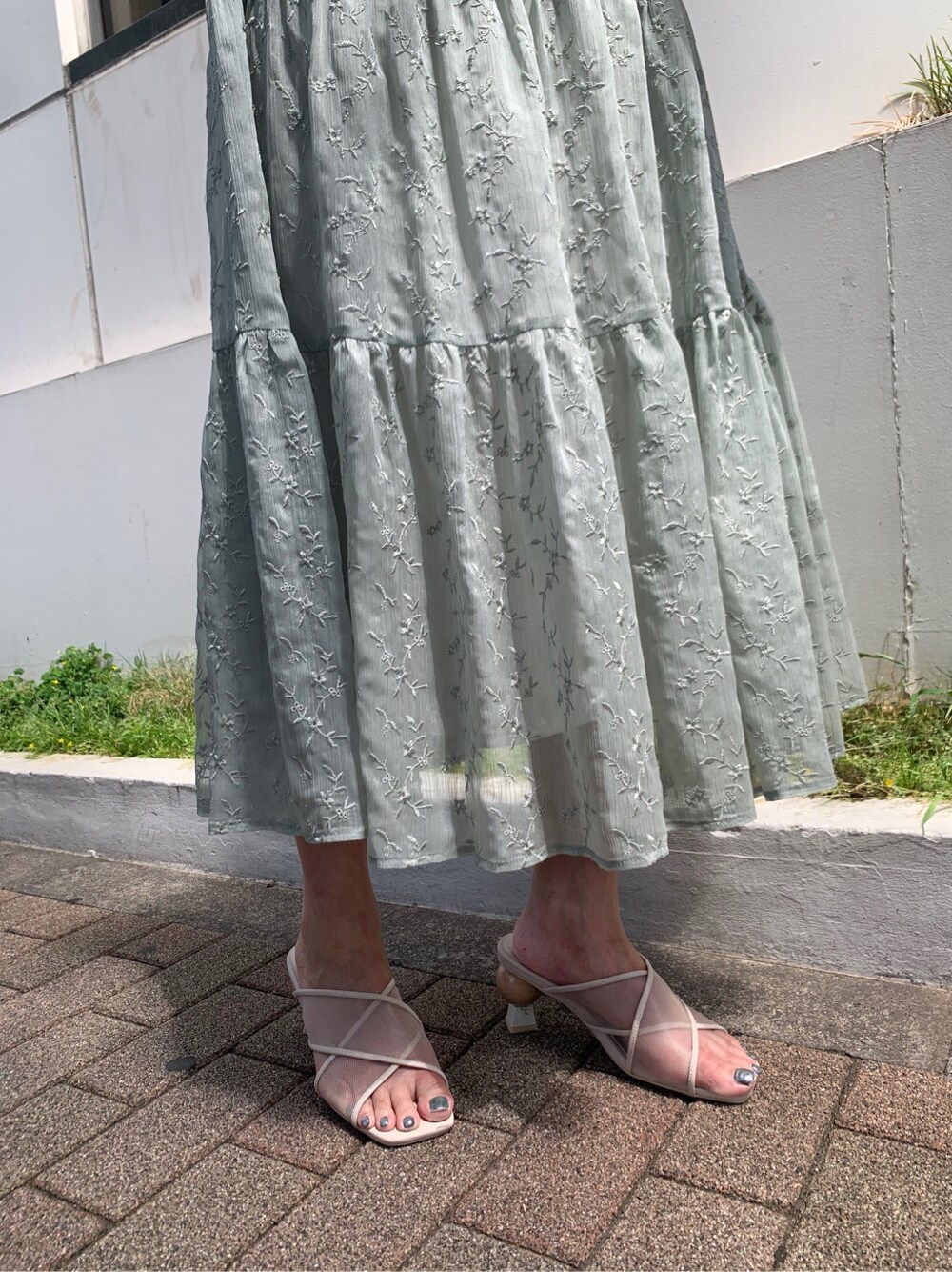 ホワイト系のハンドバッグ、グリーン系のワンピース、ベージュ系のサンダルを着用したレディースの夏コーディネートの6枚目の写真