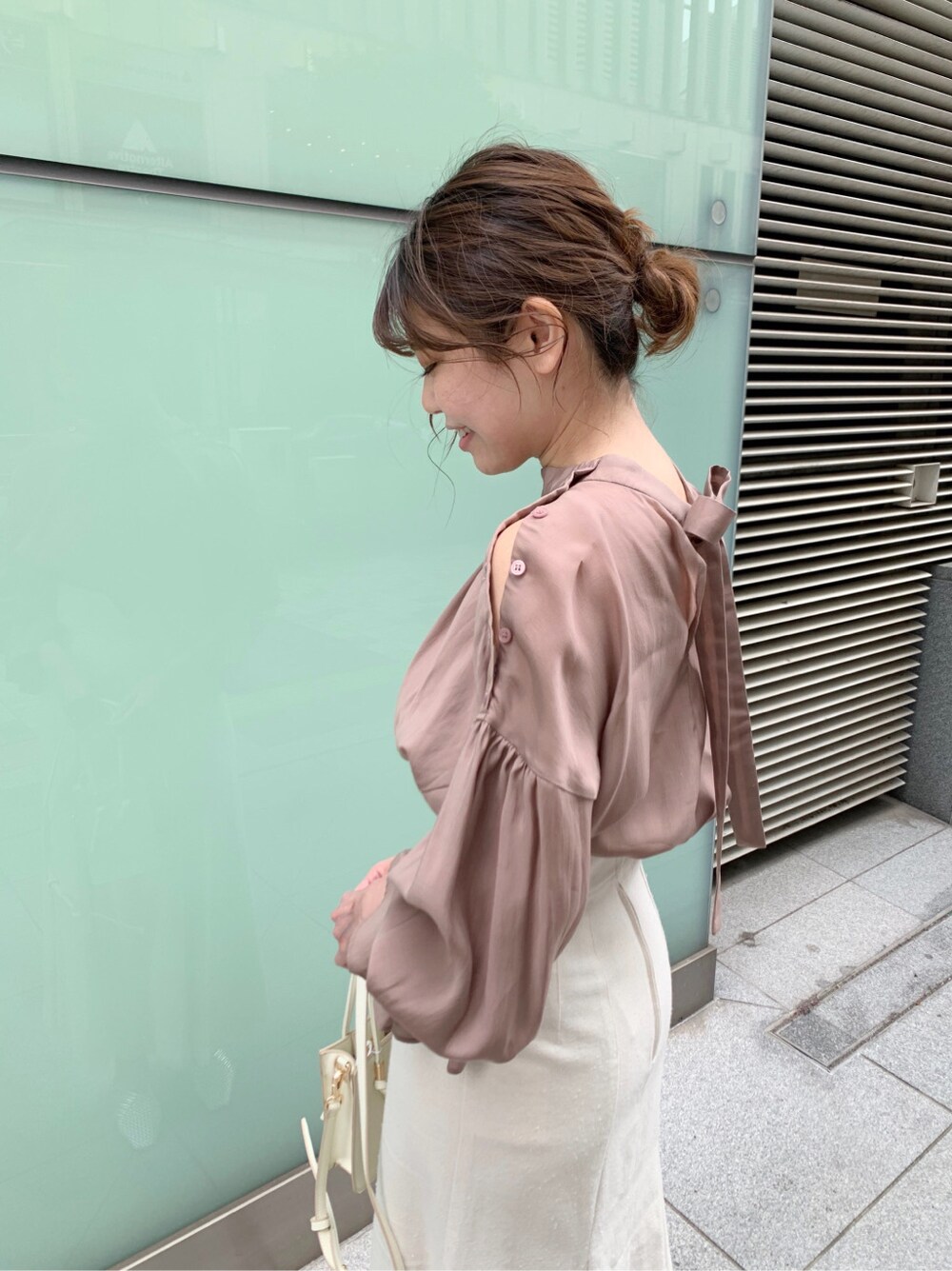 ホワイト系のスカート、シルバー系のサンダル、ホワイト系のハンドバッグを着用したレディースの冬コーディネートの2枚目の写真