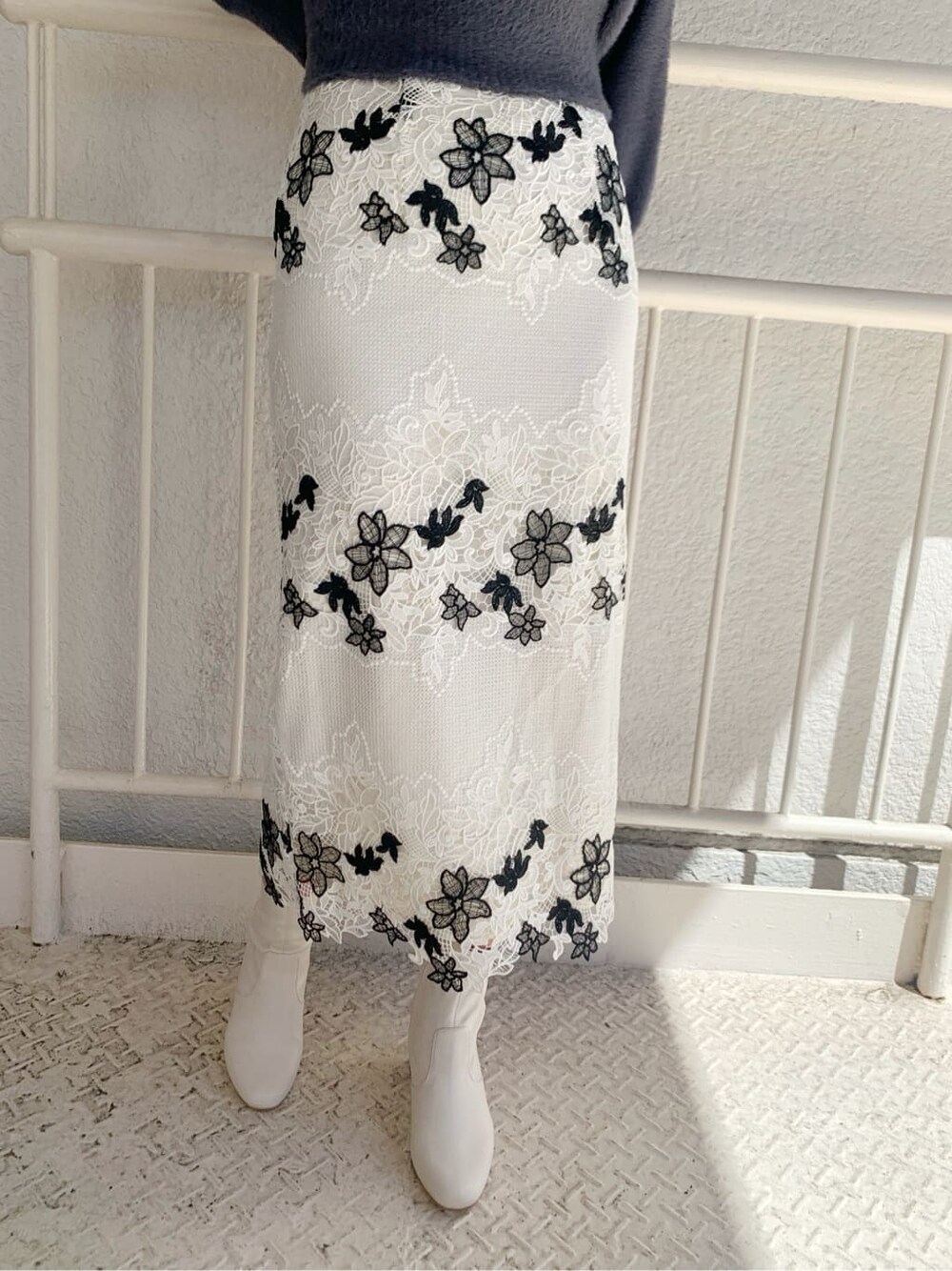 ホワイト系のその他シューズ、ホワイト系のスカート、ブルー系のニット/セーターを着用したレディースの秋コーディネートの5枚目の写真