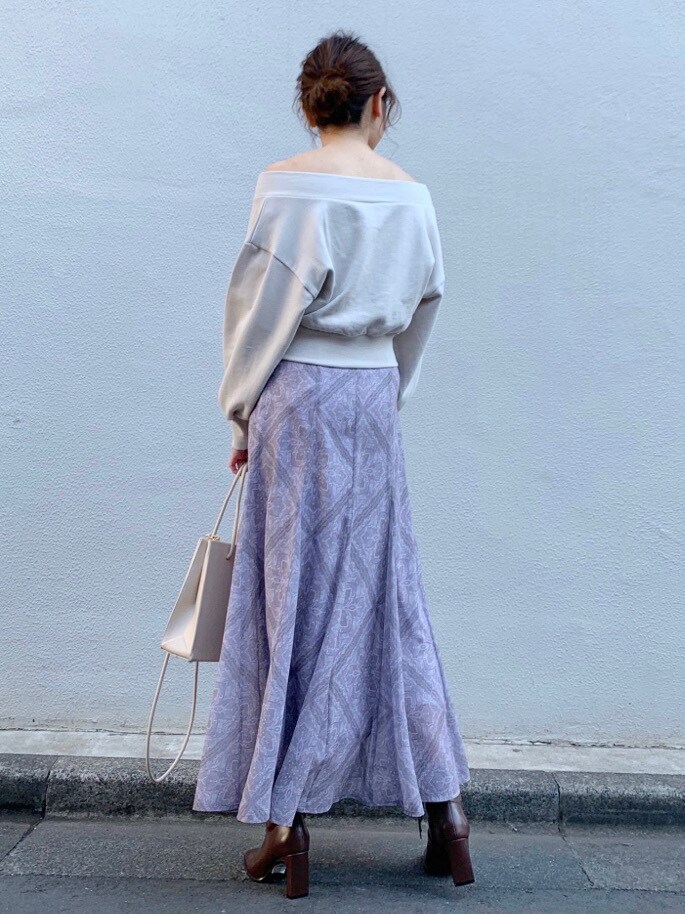 パープル系のスカート、ベージュ系のトートバッグ、ベージュ系のTシャツ/カットソーを着用したレディースの冬コーディネートの4枚目の写真