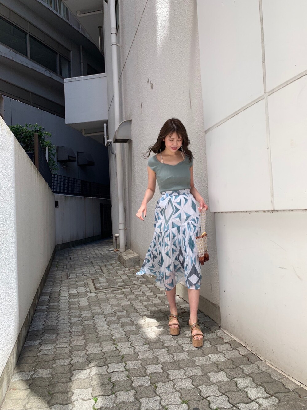 グリーン系のサンダル、ブルー系のスカート、グリーン系のニット/セーターを着用したレディースの春コーディネートの5枚目の写真