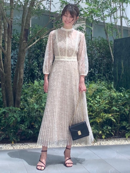 ブラック系のショルダーバッグ、ブラック系のサンダル、グリーン系のピアス（両耳用）を着用したレディースの夏コーディネートの2枚目の写真