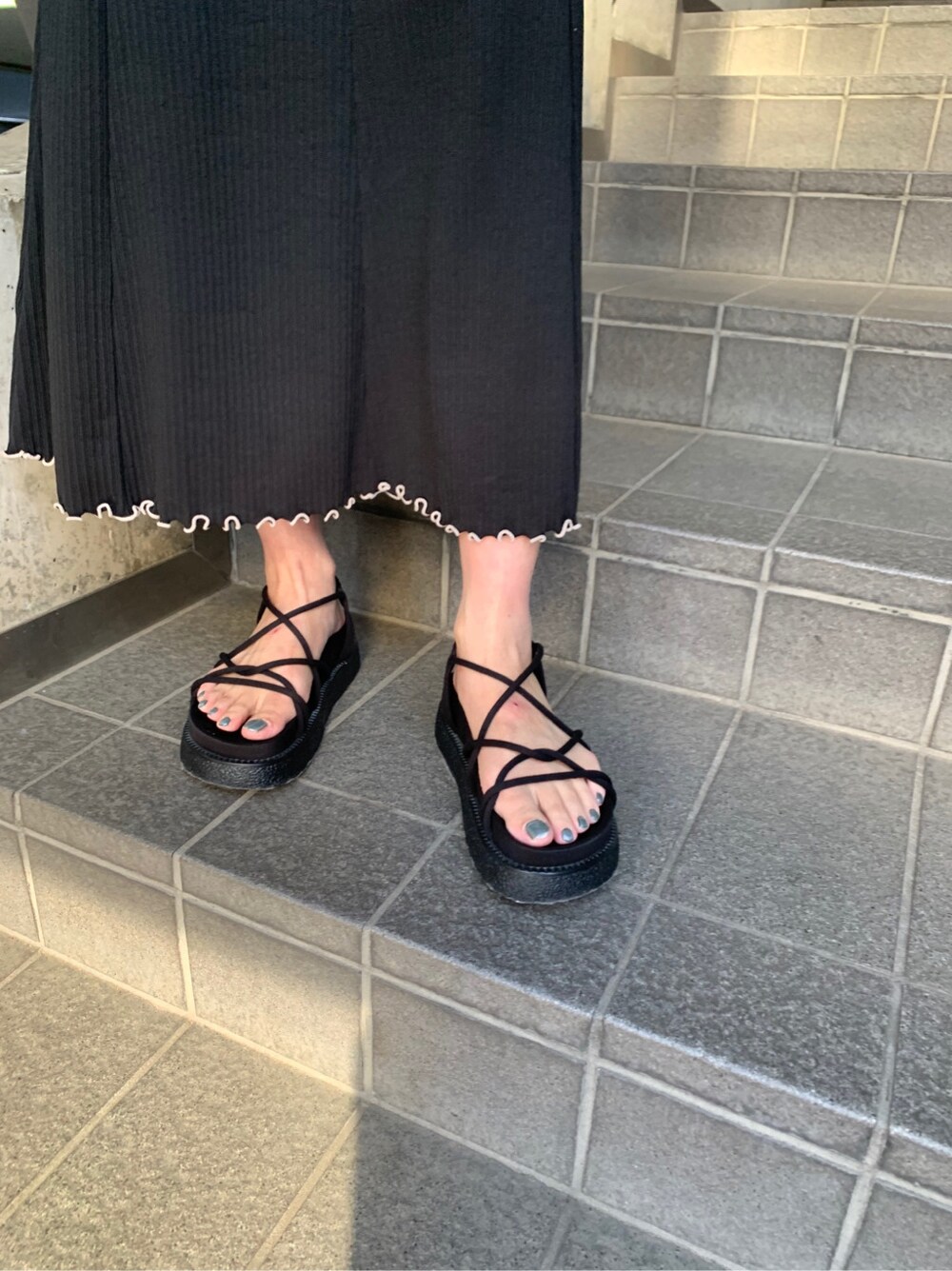 ブラック系のトートバッグ、ブラック系のサンダルを着用したレディースの春コーディネートの5枚目の写真