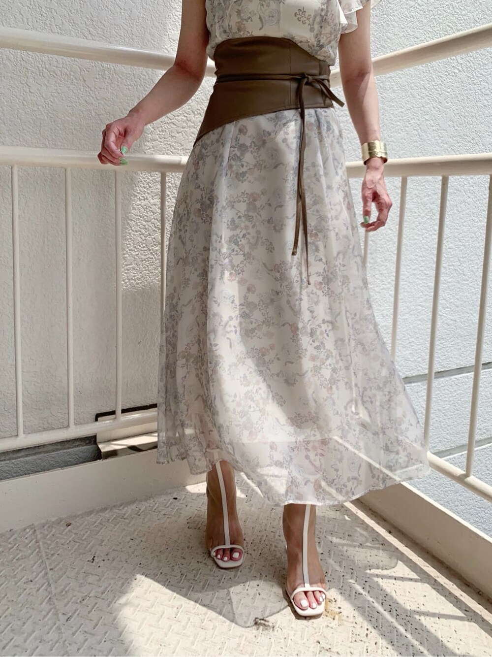 ベージュ系のワンピース、ホワイト系のその他シューズ、ゴールド系のピアス（両耳用）を着用したレディースの夏コーディネートの7枚目の写真