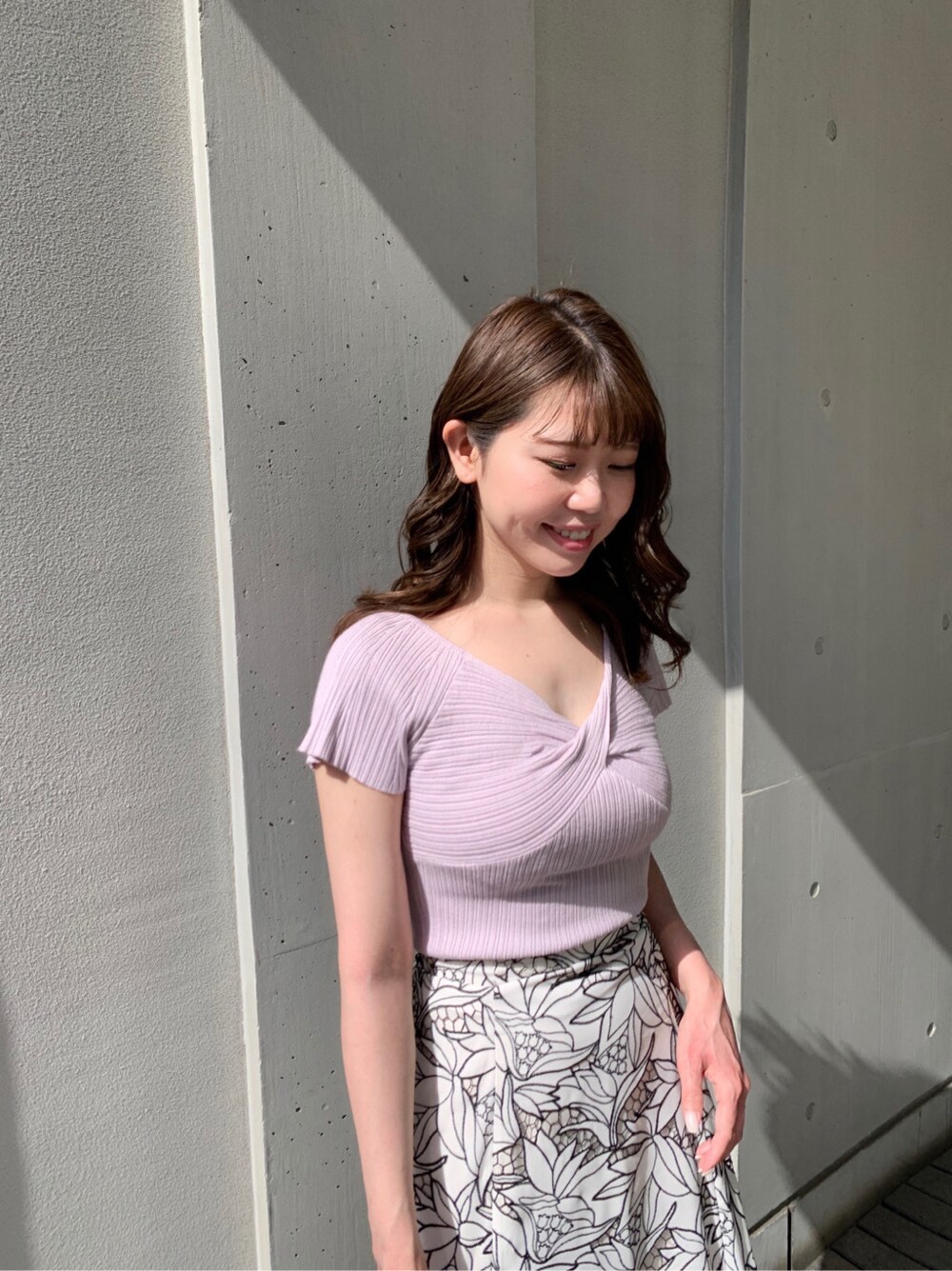 ブラック系のスカート、ホワイト系のサンダル、パープル系のニット/セーターを着用したレディースの春コーディネートの2枚目の写真