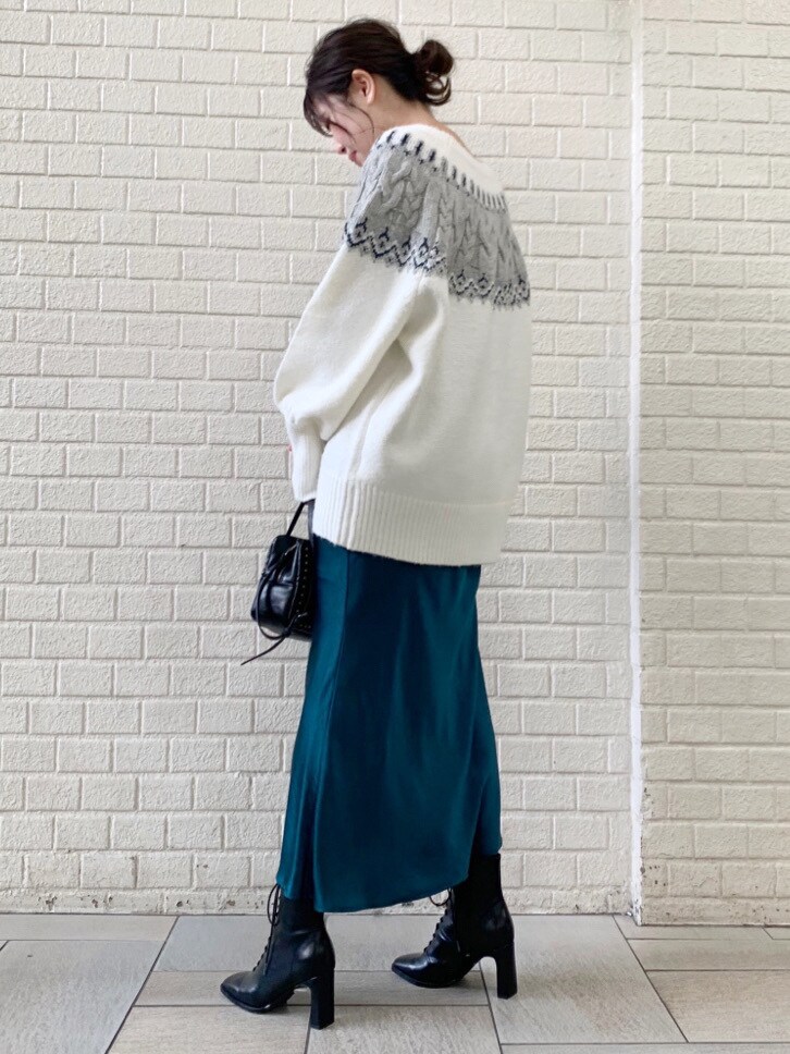 グリーン系のスカート、ホワイト系のニット/セーターを着用したレディースの冬コーディネートの2枚目の写真