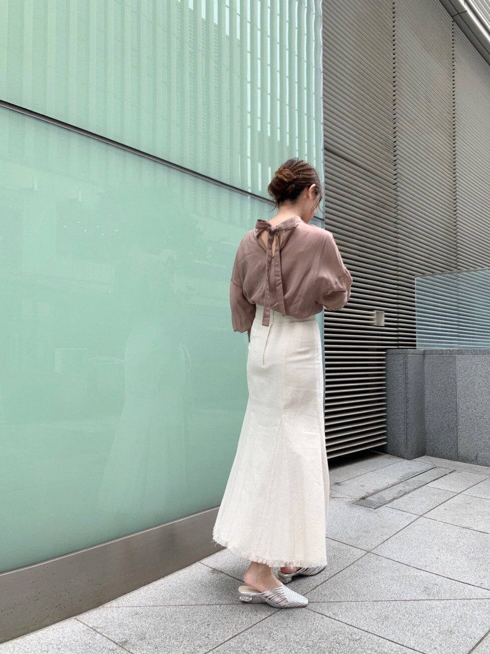 ホワイト系のスカート、シルバー系のサンダル、ホワイト系のハンドバッグを着用したレディースの冬コーディネートの3枚目の写真