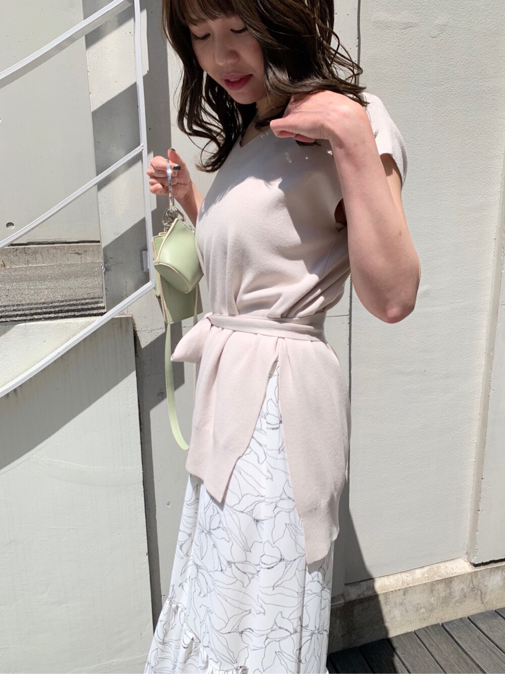 グリーン系のショルダーバッグ、ホワイト系のサンダル、ホワイト系のワンピースを着用したレディースの春コーディネートの4枚目の写真