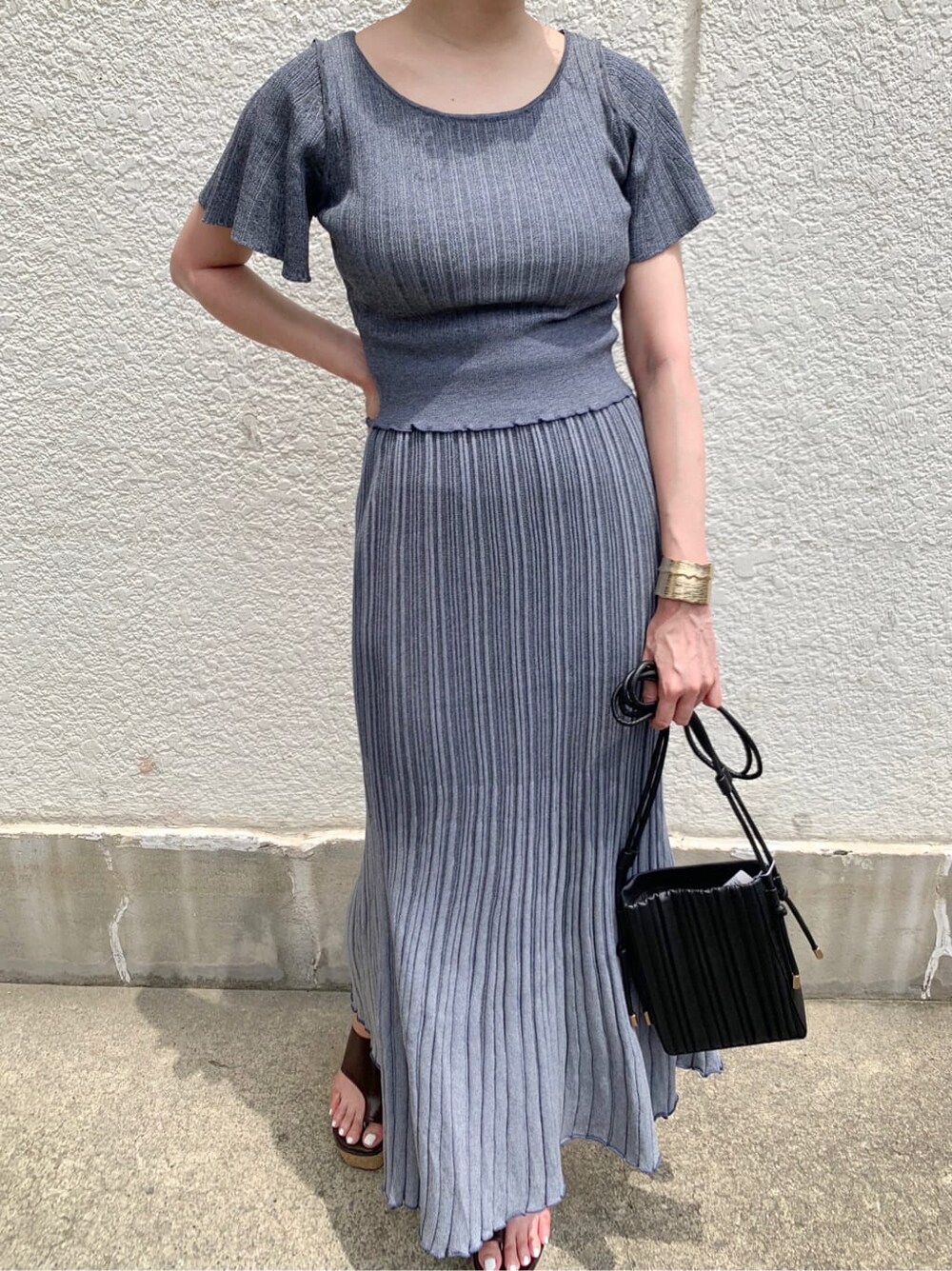 ブルー系のワンピース、ブラウン系のサンダル、ブラック系のハンドバッグを着用したレディースの夏コーディネートの7枚目の写真