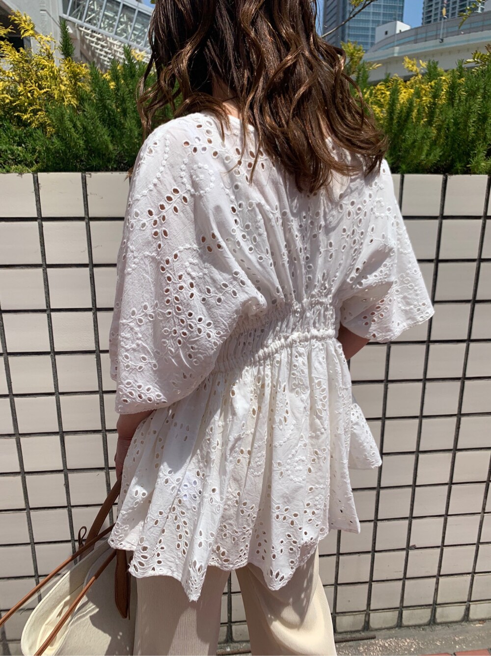 ブラウン系のトートバッグ、ホワイト系のシャツ/ブラウス、ホワイト系のその他パンツを着用したレディースの春コーディネートの2枚目の写真