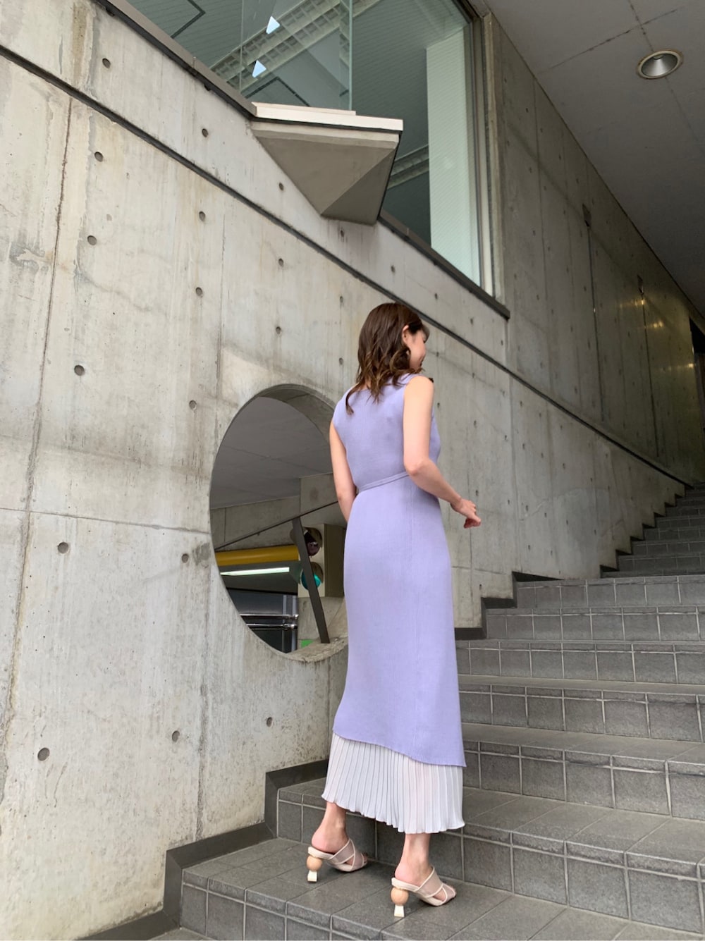 ホワイト系のハンドバッグ、ブルー系のワンピース、ベージュ系のサンダルを着用したレディースの夏コーディネートの2枚目の写真