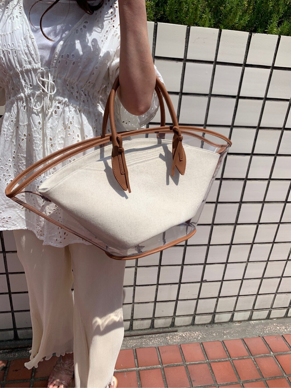 ブラウン系のトートバッグ、ホワイト系のシャツ/ブラウス、ホワイト系のその他パンツを着用したレディースの春コーディネートの6枚目の写真