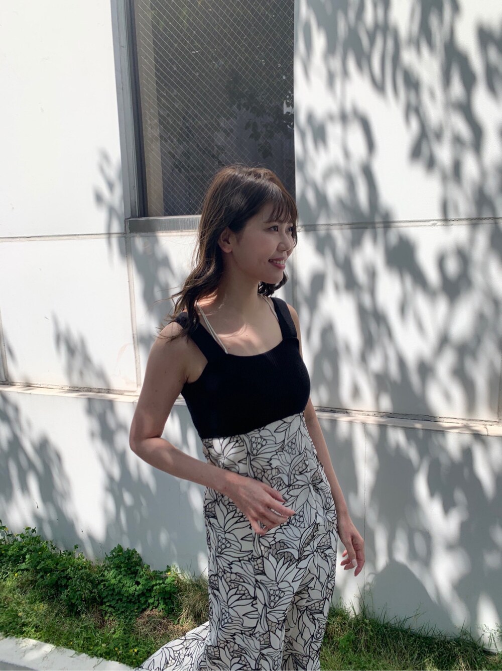 ブラック系のワンピース、ホワイト系のサンダルを着用したレディースの春コーディネートの2枚目の写真