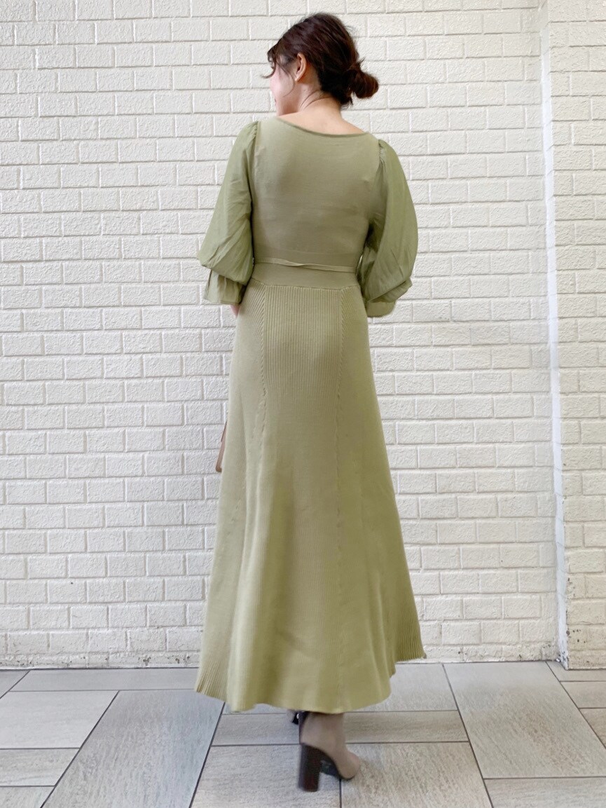 ホワイト系のトレンチコート、グリーン系のワンピースを着用したレディースの冬コーディネートの3枚目の写真