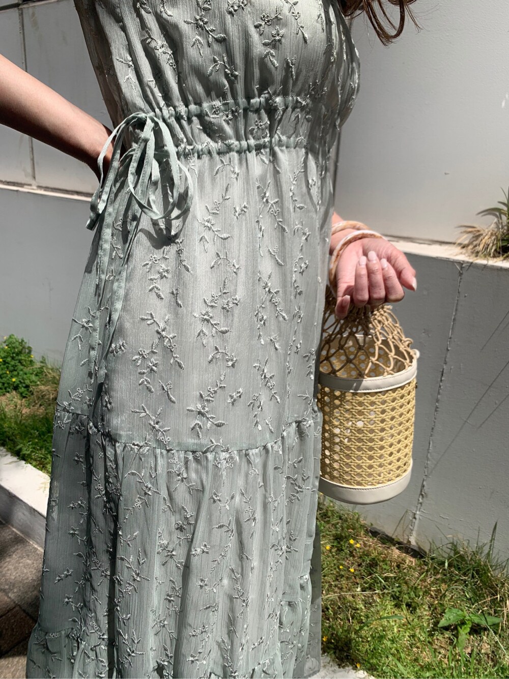 ホワイト系のハンドバッグ、グリーン系のワンピース、ベージュ系のサンダルを着用したレディースの夏コーディネートの5枚目の写真